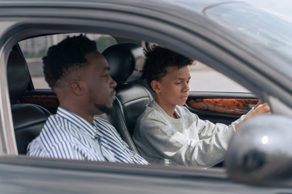 Crafting Captivating Headlines: Your awesome post title goes here A father sits beside his son who is learning to drive, inside a car.